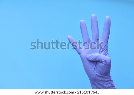 a hand in medical blue gloves shows a countdown of time or the number of drugs