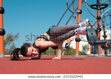 a sporty girl does yoga exercises on a sports field in the summer outdoors