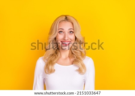 Photo of dreamy cute lady dressed white shirt looking up empty space isolated yellow color background