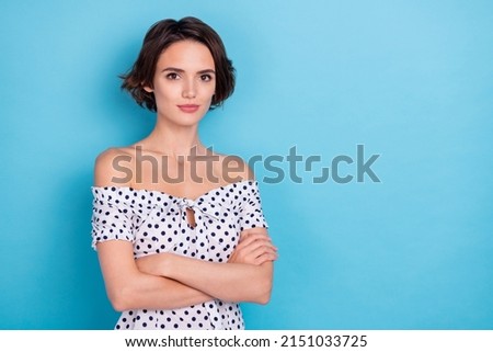 Photo of calm satisfied person crossed arms look camera empty space isolated on blue color background