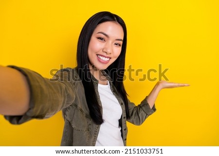 Photo of attractive casual wear lady recommend product shooting herself isolated on yellow color background