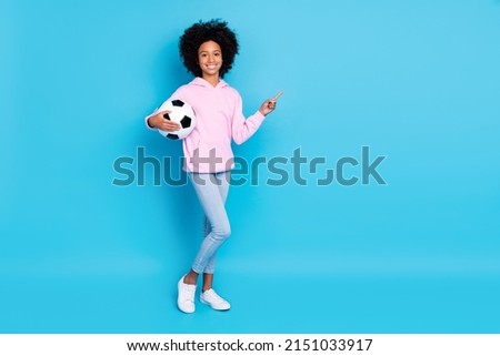 Photo of young girl football indicate finger empty space select suggest direct promo isolated over blue color background