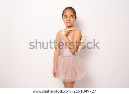 Beautiful little ballerina standing isolated over white background.