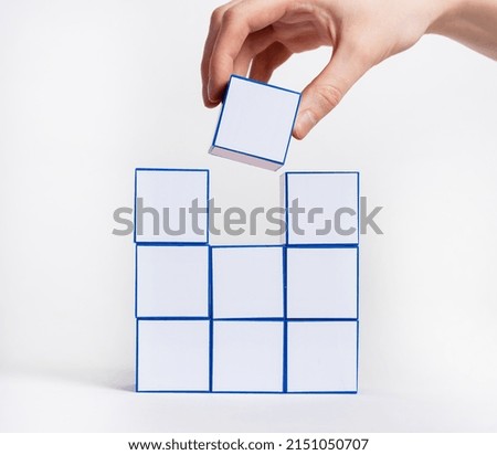 Hand stacking white cubes. Adding missing last element concept. High quality photo