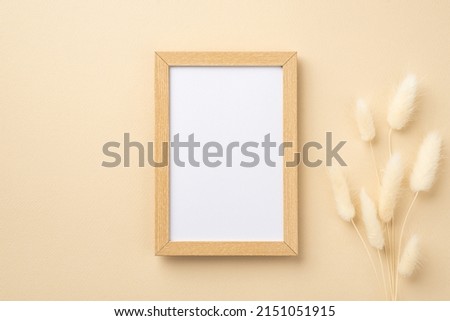Business concept. Top view photo of wooden photo frame and white lagurus flowers on isolated beige background with copyspace
