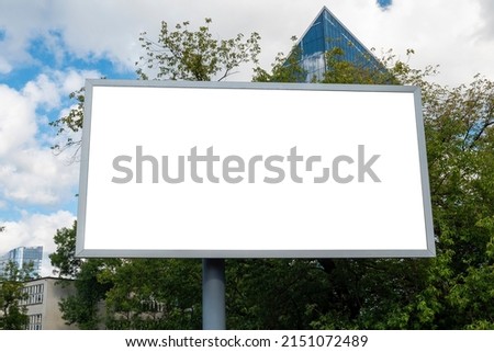 Blank white billboard for advertisement in front of modern office building with glass facade
