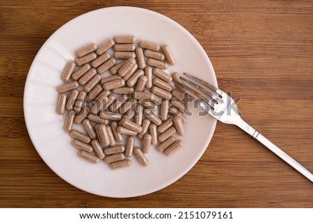 gel medical capsules, vitamins, dietary supplements lying on a plate. A pile of pills. Vitamins in capsules. Poured tablets with spoon and fork Royalty-Free Stock Photo #2151079161