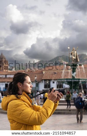 Male tourist taking a picture in the main square of Cuzco