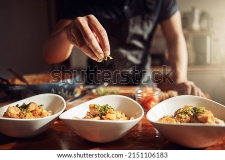 Food as good as the restaurant makes it. Shot of an unrecognisable man preparing a delicious meal at home. Royalty-Free Stock Photo #2151106183