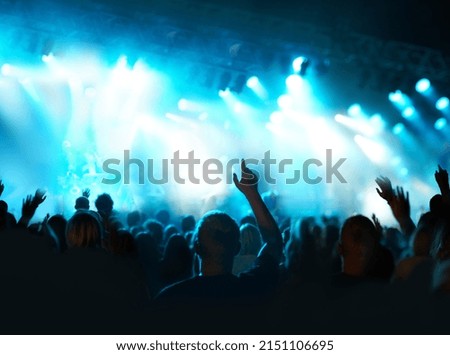 Music in the night under the lights. Shot of a fans watching a live concert. Royalty-Free Stock Photo #2151106695