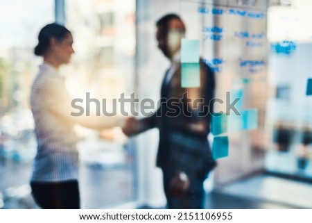 Determined to achieve success. Defocused shot of two businesspeople shaking hands in an office. Royalty-Free Stock Photo #2151106955