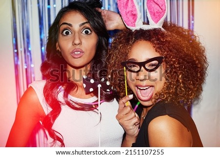 We might forget, but the camera will remember. Shot of two beautiful young women having fun with props in a photobooth. Royalty-Free Stock Photo #2151107255