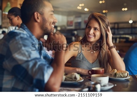 Its turning into an impressive first date. Cropped shot of a young couple on a date in a cafe. Royalty-Free Stock Photo #2151109159