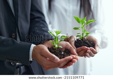 Preserving nature to help it flourish. Shot of two colleagues holding plants. Royalty-Free Stock Photo #2151109771