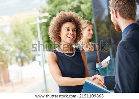 Go outside and meet new people. Shot of a businesswoman and businessman shaking hands outdoors. Royalty-Free Stock Photo #2151109863