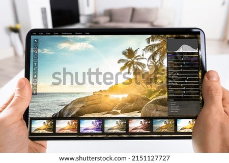 Graphic Designer Editing Photo On Tablet Computer