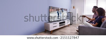 Affectionate Young Family Watching TV At Home Royalty-Free Stock Photo #2151127847