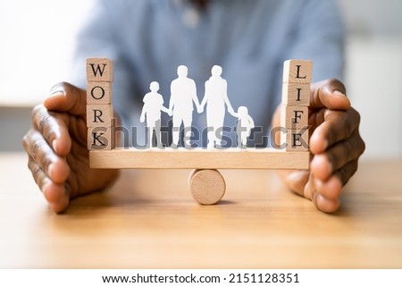 Protecting Balance Between Work And Life With Family Paper Cut Out On Seesaw