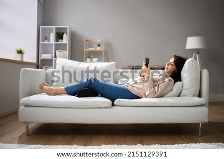 Woman Using Footrest To Reduce Back Strain And Feet Fatigue Royalty-Free Stock Photo #2151129391