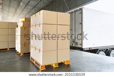 Packaging Boxes Stacked on Pallets Load with Shipping Cargo Container. Delivery Trucks Loading at Dock Warehouse. Supply Chain. Shipment Boxes. Distribution Warehouse Freight Truck Transport Logistics Royalty-Free Stock Photo #2151130159
