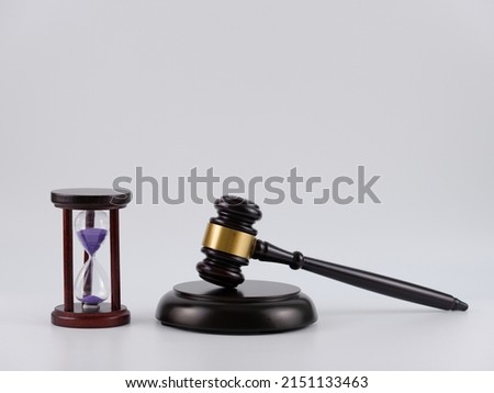 A purple sand hourglass and wooden gavel isolated with white background. Royalty-Free Stock Photo #2151133463