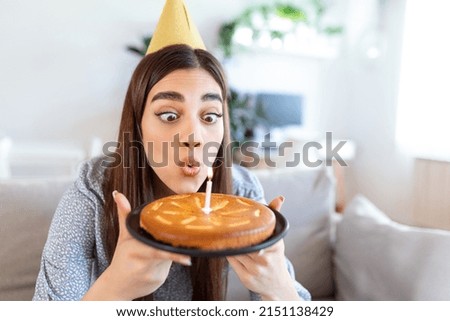 New normal concept. Happy woman celebrating her birthday alone. young woman holding a cake. Birthday party at home. Family video call. Social distancing. Life at home. making a wish