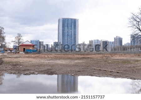 Construction of a new district in the city. Dirty ground and water in front of the New Tall Houses