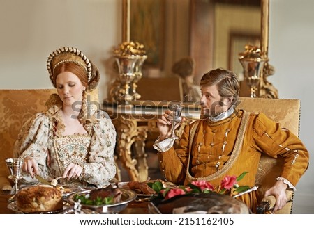 Enjoying the comfort of the palace. Shot of a noble couple eating together. Royalty-Free Stock Photo #2151162405