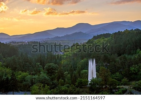 Amazing abandoned building, former Memorial for the 50th anniversary of Soviet Armenia in Dilijan, Armenia surrounded with green forest at colorful sunset