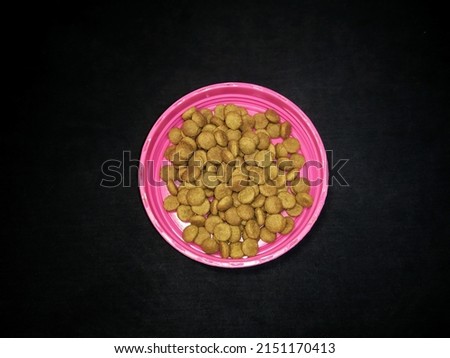 Cat food product in the form of dry biscuit isolated on black background