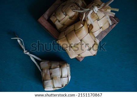 Kupat (in Javanese and Sundanese) or ketupat (in Indonesian and Malay), or tipat (in Balinese) is a rice cake packed inside a diamond-shaped container of woven palm leaf pouch
