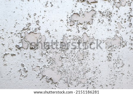 Old gray paint peeling from wall texture background. Cracked paint on metallic background. Grunge background