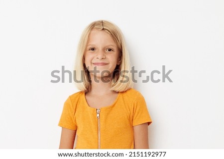 cheerful girl in a yellow t-shirt posing emotions light background