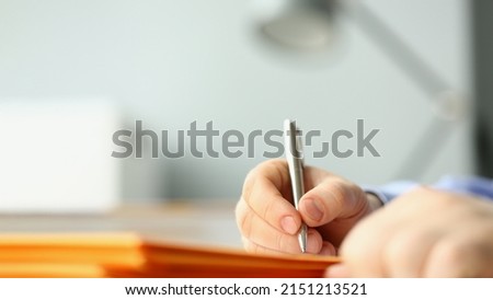 Male hand writing personal address on yellow envelope