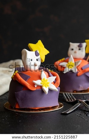 Design cake with cat figures on a dark background. close up