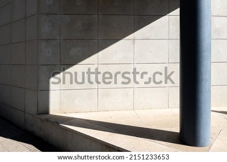 A photo of architecture details of modern concrete wall of a building with a pillar