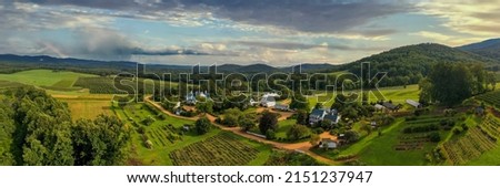 An aerial panoramic view of rural ranch with planted field near to a dense forest in bright sunlight Royalty-Free Stock Photo #2151237947