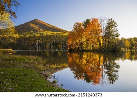 A beautiful landscape view of Peaks of Otter Lake in the autumn on a beautiful sunny day in Virginia, United States