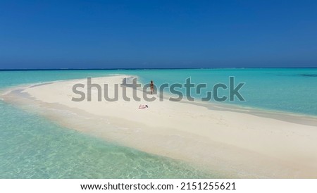 Girl running on a white sandy beach. On the white sandy beach of Bora Bora island, Maldives, Tahiti. Royalty-Free Stock Photo #2151255621
