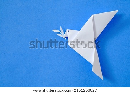 Dove of peace on blue sky background concept from origami toy leisure and hobby and poster with emblem no to war and yes to peace. Royalty-Free Stock Photo #2151258029