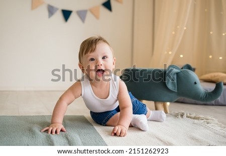 Caucasian baby boy crawls on the floor in the children's room with toys. Happy childhood Royalty-Free Stock Photo #2151262923