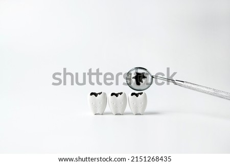  Decay tooth with black cavity reflect on mirror mouth on white background, checkups with dentist quickly                                                  Royalty-Free Stock Photo #2151268435
