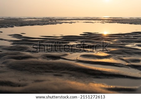A Sunset on the beach on the French opal coast with sea and sand with structures. Copy space. Horizon