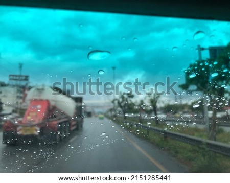 Rain falling on car windshield,drive car on street in city at heavy rain storm,selective focus.