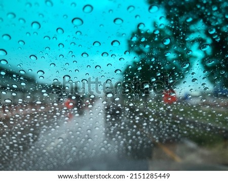 Rain falling on car windshield,drive car on street in city at heavy rain storm,selective focus.
