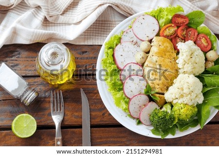 healthy eating plate of grilled chicken breast and vegetable salad over rustic wooden table. Ketogenic and Paleolithic Diet. top view Royalty-Free Stock Photo #2151294981
