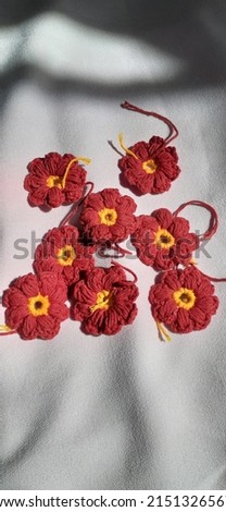 Small red flowers handmade crochet crafts on a white background