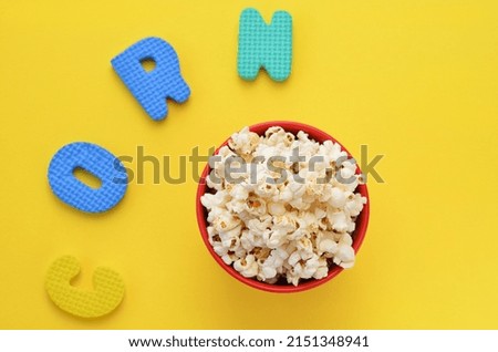 popcorn in a bucket and the inscription corn on a yellow background
