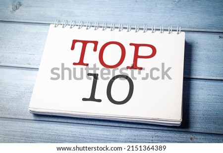 Top 10 sign on the white notepad on the blue wooden desk