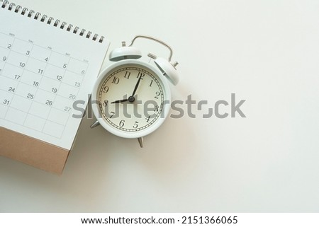 close up of calendar and alarm clock on the white table background, planning for business meeting or travel planning concept